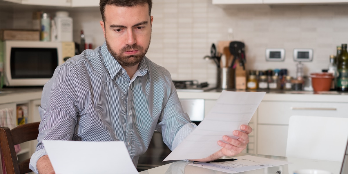 A man calculating bills, debts and repayments to improve his bad credit score
